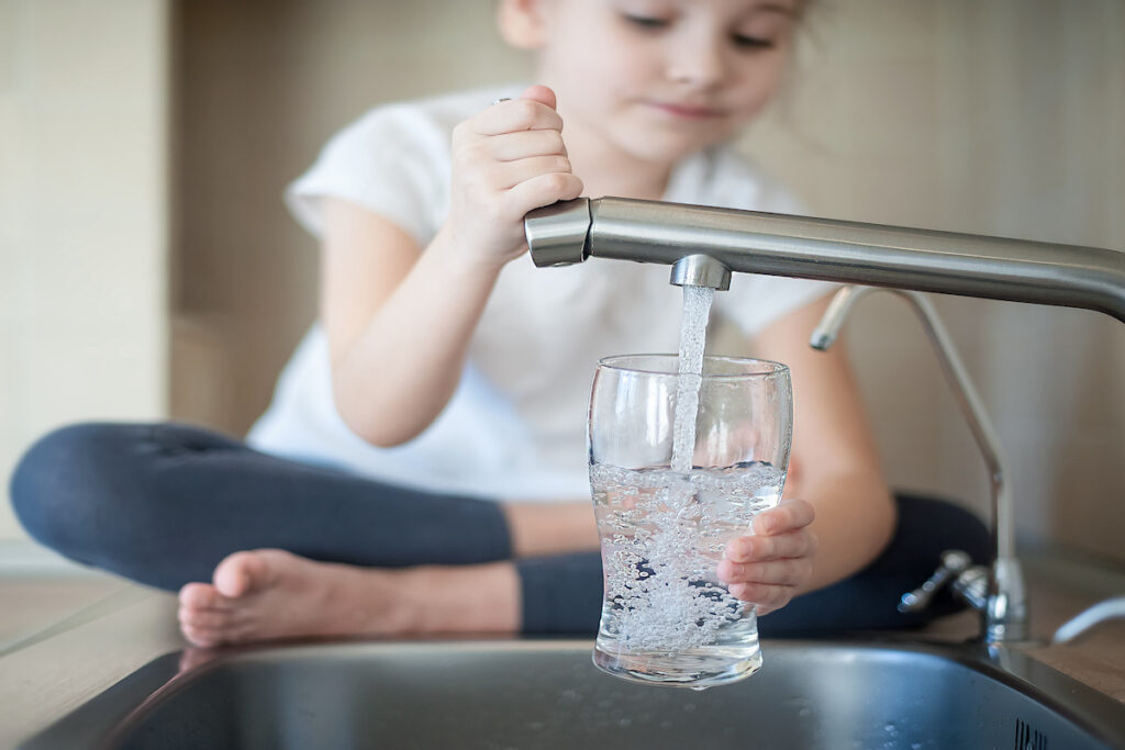 Girl getting water from kitchen sink