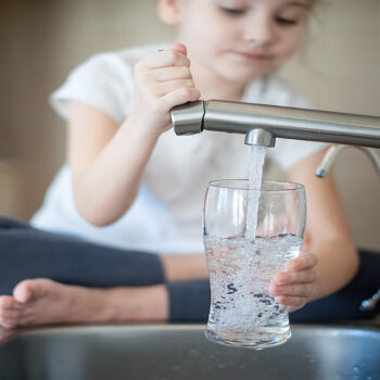 Girl getting water from kitchen sink